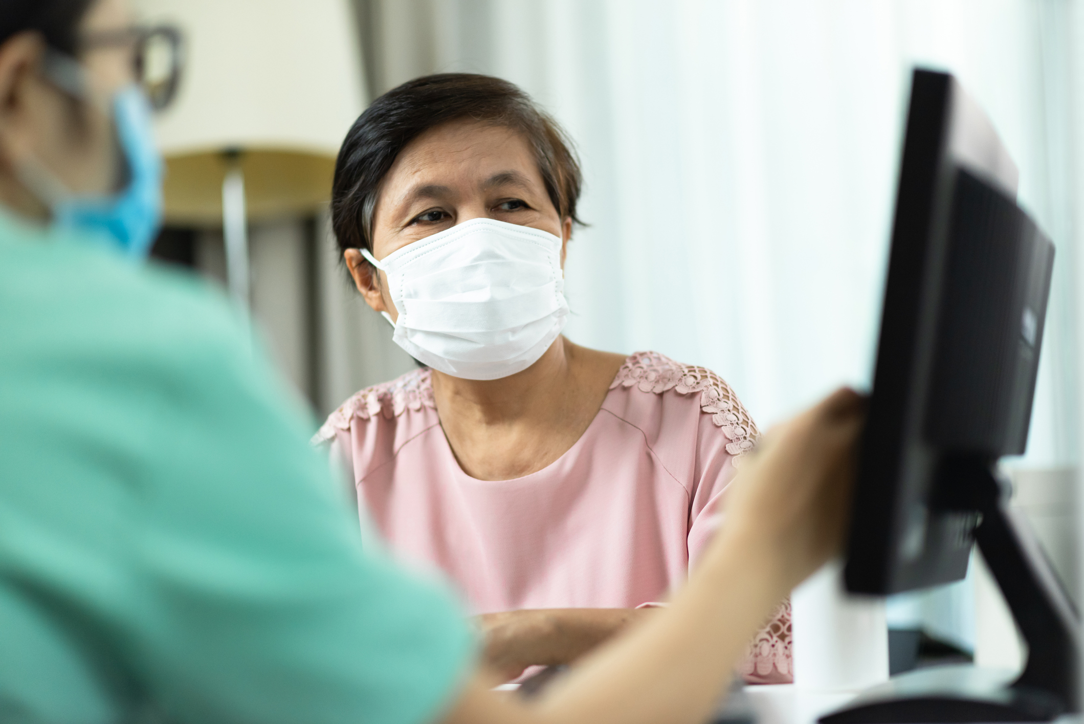 A health care worker shows a patient a computer screen