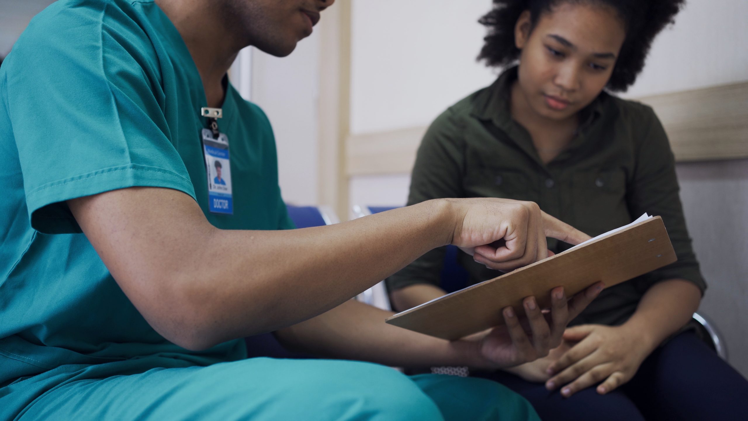 Male health care worker talking to female patient