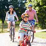 A family rides bicycles on a community bike path