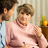 A community health worker talks with a patient.