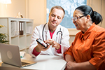 Healthcare provider showing a tablet computer to a patient.