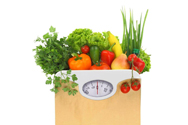 A grocery bag of vegetables sits atop an analog dial scale