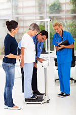 A doctor and nurse record a patient's weight