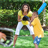 A family plays baseball in their yard