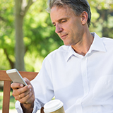 A man looks at the screen of his smartphone.