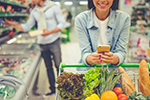 A couple buys healthy fruits and vegetables in a grocery store.