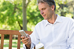 A man looks at the screen of a smart phone.