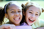 Two young girls show off their smiles.