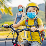 A young boy rides a bicycle to school.