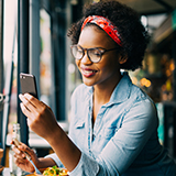 A woman looks at her smartphone.