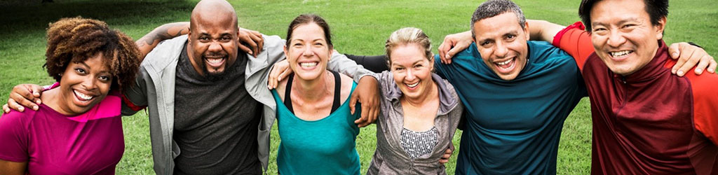 A multicultural group of friends outdoors at a park.