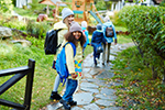 Families walk down a paved pathway to a school building.