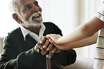 An older man sits and talks with a young child.